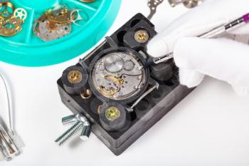 watchmaker workshop - repairing old mechanical watch close up on white table