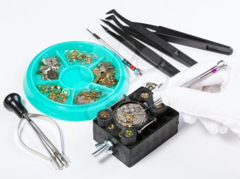 watchmaker workshop - repairing old mechanical watch on white table