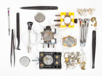 watchmaker workshop - top view of watch repairing tools on white background