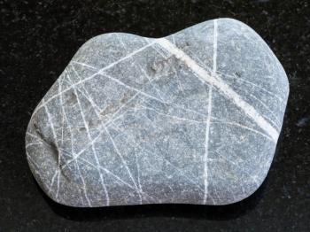 macro shooting of natural mineral rock specimen - pebble of Greywacke sandstone on dark granite background
