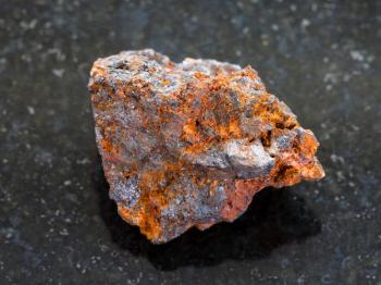 macro shooting of natural mineral rock specimen - rough Hematite (iron ore) stone on dark granite background
