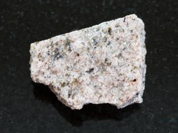 macro shooting of natural mineral rock specimen - rough Schist stone on dark granite background