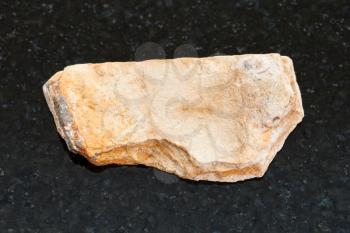macro shooting of natural mineral rock specimen - rough Shale stone on dark granite background