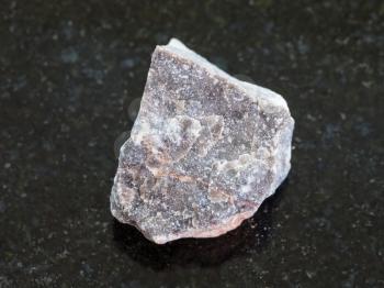 macro shooting of natural mineral rock specimen - rough Limestone stone on dark granite background