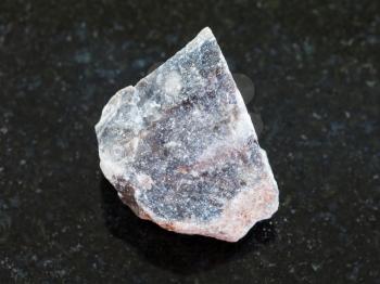 macro shooting of natural mineral rock specimen - raw Limestone stone on dark granite background