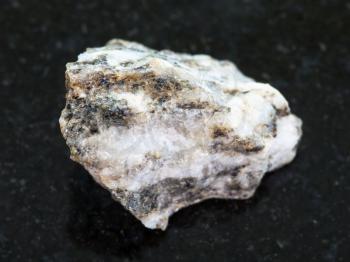 macro shooting of natural mineral rock specimen - Gneiss stone on dark granite background