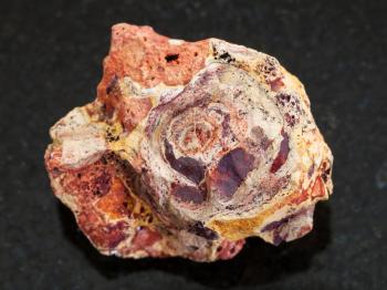 macro shooting of natural mineral rock specimen - rough Bauxite (aluminium ore) stone on dark granite background