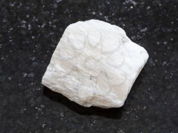 macro shooting of natural mineral rock specimen - raw Gypsum stone on dark granite background
