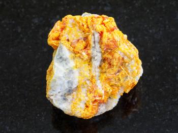 macro shooting of natural mineral rock specimen - raw Orpiment crystals on white dolomite stone on dark granite background from Kabardino-Balkarian Republic, Northern Caucasus Region, Russia