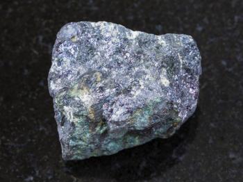 macro shooting of natural mineral rock specimen - raw bornite stone on dark granite background from Azerbaijan