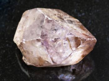 macro shooting of natural mineral rock specimen - raw crystal of amethyst gemstone on dark granite background from Yakutia, Russia