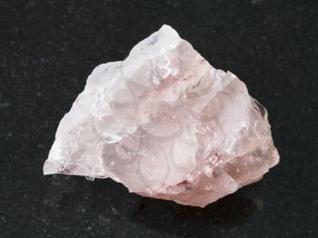 macro shooting of natural mineral rock specimen - raw crystal of rose quartz gemstone on dark granite background from Kiv-Guba mine, Karelia, Russia
