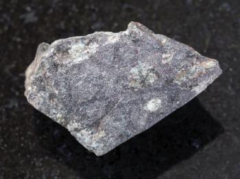 macro shooting of natural mineral rock specimen - raw porphyritic Basalt stone on dark granite background