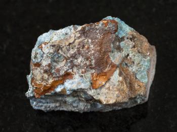 macro shooting of natural mineral rock specimen - rough Scorodite stone on dark granite background from Jezkazgan region, Kazakhstan
