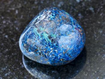 macro shooting of natural mineral rock specimen - polished Azurite gemstone on dark granite background
