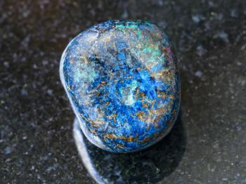 macro shooting of natural mineral rock specimen - pebble of Azurite gemstone on dark granite background