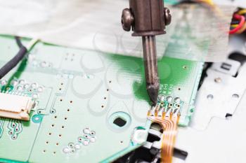 repairing of electric circuit board with soldering iron close up