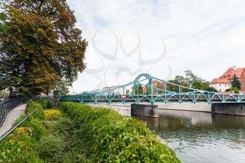 travel to Poland - view of pedestrian Tumski Bridge (Most Tumski, Lovers Bridge, Cathedral Bridge, Green Bridge) over Oder river in Wroclaw city in september