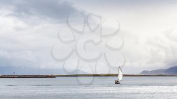 travel to Iceland - view of sailing boat in Atlantic ocean from promenade Sculpture and Shore Walk in Reykjavik city in september