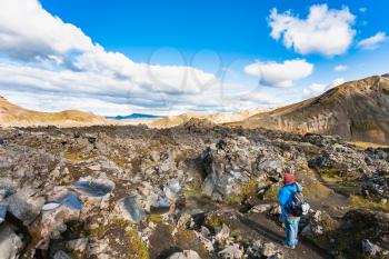 travel to Iceland - tourist at Laugahraun volcanic lava field in Landmannalaugar area of Fjallabak Nature Reserve in Highlands region of Iceland in september