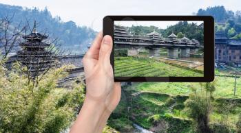 travel concept - tourist photographs Chengyang Wind and Rain (Fengyu, Yongji, Panlong) Bridge in Sanjiang Dong Autonomous County in China in spring on tablet