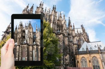 travel concept - tourist photographs Kolner Dom (Cathedral Church of Saint Peter) in Cologne city in Germany on tablet