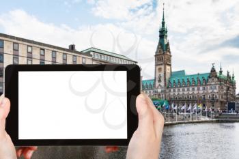 travel concept - tourist photographs quay of Binnenalster (Inner Alster Lake) and Hamburger Rathaus in Hamburg in autumn on tablet with cut out screen for advertising logo