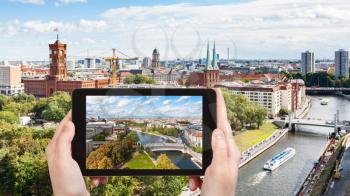 travel concept - tourist photographs Berlin city with Spree river on tablet