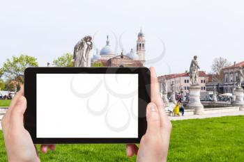 travel concept - tourist photographs Prato della Valle and Basilica di Santa Giustina in Padua city in Italy in spring on tablet with cut out screen for advertising logo