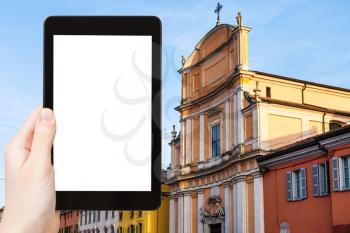 travel concept - tourist photographs Chiesa di Ognissanti in Mantua city in Italy in spring on tablet with cut out screen for advertising logo