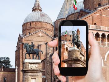 travel concept - tourist photographs The Equestrian Statue of Gattamelata by Donatello and Basilica of Saint Anthony of Padua on square piazza del Santo in Padua city in Italy on smartphone