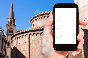travel concept - tourist photographs Rotonda di San Lorenzo and bell tower of Basilica of Sant' Andrea in Mantua city in Italy in spring on smartphone with cut out screen for advertising logo