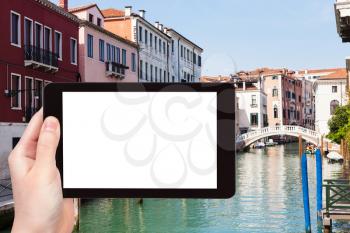 travel concept - tourist photograps bridge and Rio San Lorenzo canal in Venice city in Italy in spring on tablet with cut out screen for advertising logo