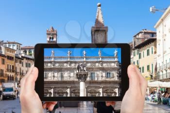 travel concept - tourist photographs square Piazza delle Erbe in Verona city in Italy on tablet