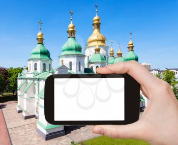 travel concept - tourist photographs Saint Sophia (Holy Sophia, Hagia Sophia) Sobor in Kiev city in Ukraine on smartphone with cut out screen for advertising logo