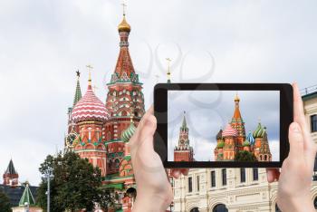 travel concept - tourist photographs Saint Basil Cathedral (Pokrovsky Cathedral) and Spasskaya clock Tower of Moscow Kremlin on Red Square from Zaryadye district in september on tablet