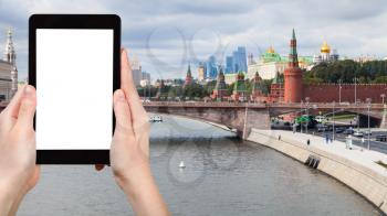 travel concept - tourist photographs Moscow city and Kremlin in autumn on tablet with cut out screen for advertising logo