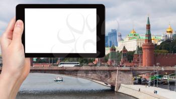 travel concept - tourist photographs Moskvoretskaya embankment, Bolshoy Moskvoretsky bridge and Kremlin in Moscow city in autumn on tablet with cut out screen for advertising logo