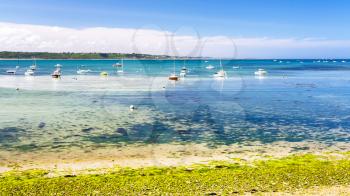 travel to France - boats in bay Anse de Perros of English Channel near Perros-Guirec commune on Pink Granite Coast of Cotes-d'Armor department in the north of Brittany in sunny summer day