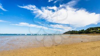 travel to France - view of sand beach Plage de la Baie de Launay on bay Anse de Launay of English Channel in Paimpol region of Cotes-d'Armor department of Brittany under blue sky in sunny summer day