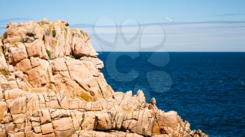 travel to France - pink granite cliff of Ile-de-Brehat island in Cotes-d'Armor department of Brittany in summer sunny day