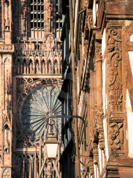 trave to France - urban lantern on street Rue Merciere and west facade of Strasbourg Cathedral in summer evening
