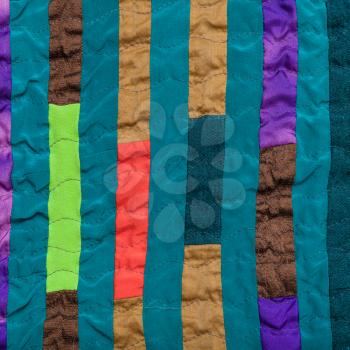 textile background - stitched patchwork headscarf from narrow silk strips