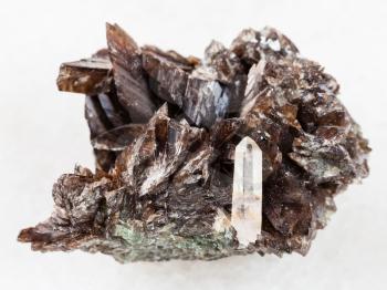 macro shooting of natural mineral rock specimen - raw crystals of axinite stone on white marble background