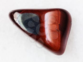 macro shooting of natural mineral rock specimen - polished Ox's eye gemstone on white marble background from South Africa