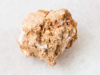 macro shooting of natural mineral rock specimen - rough travertine stone on white marble background