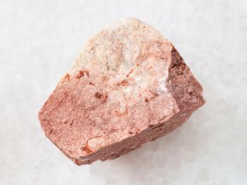 macro shooting of natural mineral rock specimen - raw calcareous sandstone stone on white marble background