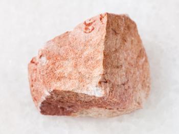 macro shooting of natural mineral rock specimen - rough calcareous sandstone stone on white marble background