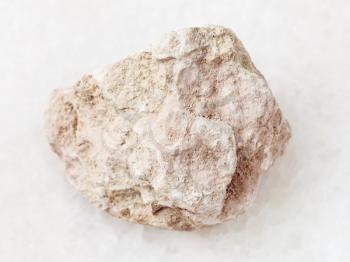 macro shooting of natural mineral rock specimen - raw marl stone on white marble background