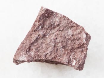 macro shooting of natural mineral rock specimen - rough Aleurolite stone on white marble background